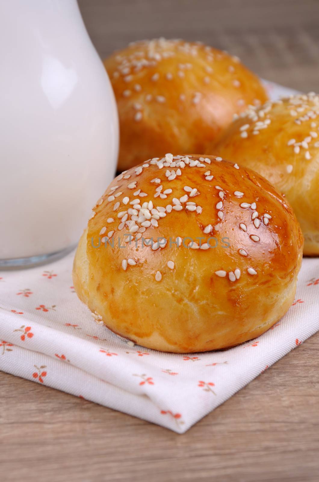 Buns with sesame seeds in a napkin on table