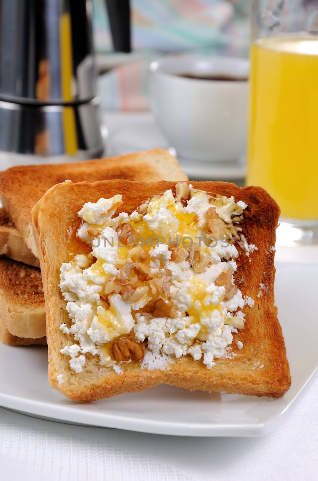 Crisp, fresh  toast ricotta, honey and nuts for breakfast with orange juice and coffee