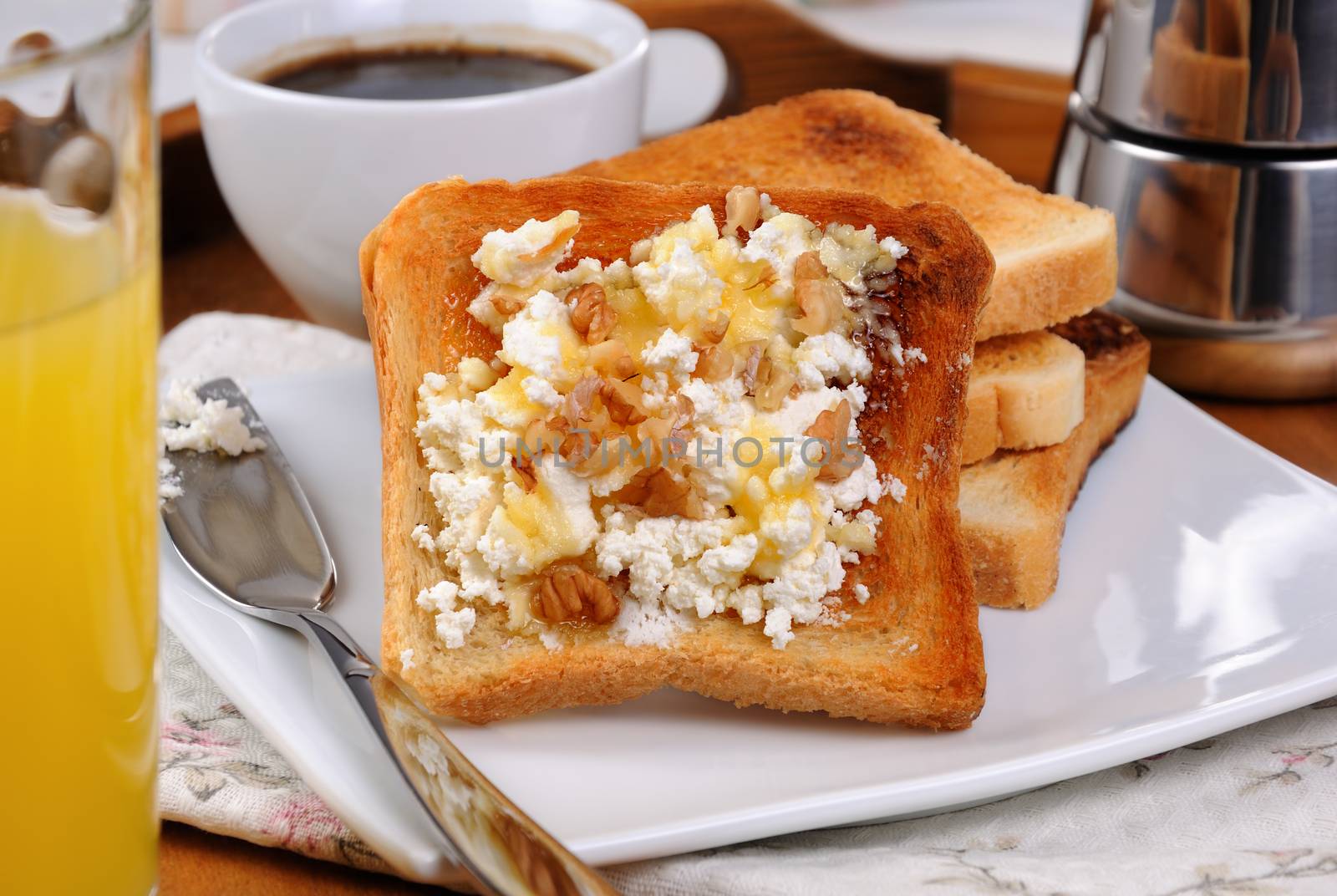 Crisp, fresh  toast ricotta, honey and nuts for breakfast with orange juice and coffee