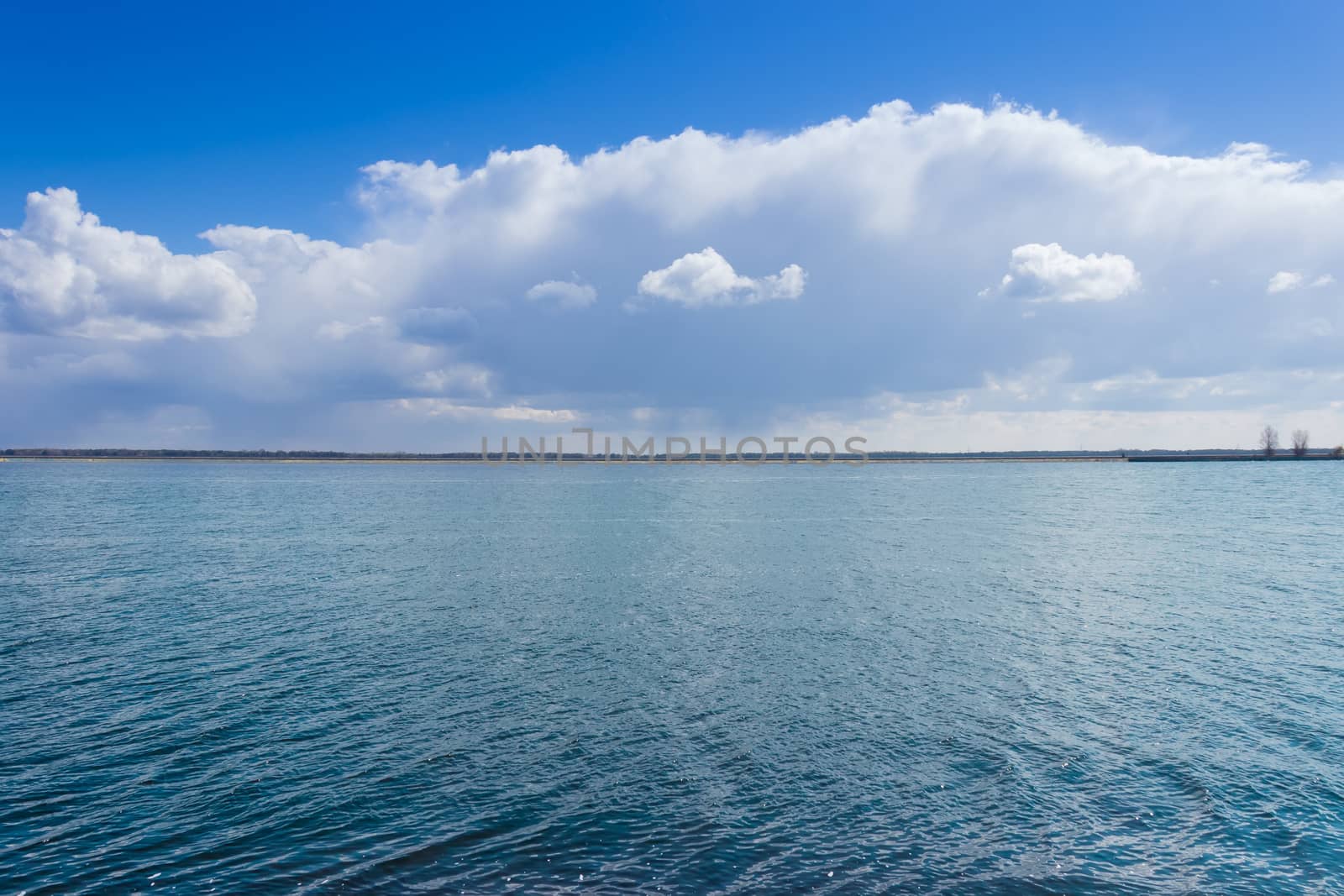 Water surface of the bay against the sky with clouds by anmbph