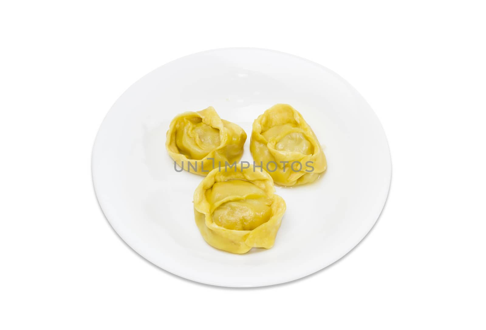 Three boiled manti (dumplings, meat dumplings) on a white dish on a light background
