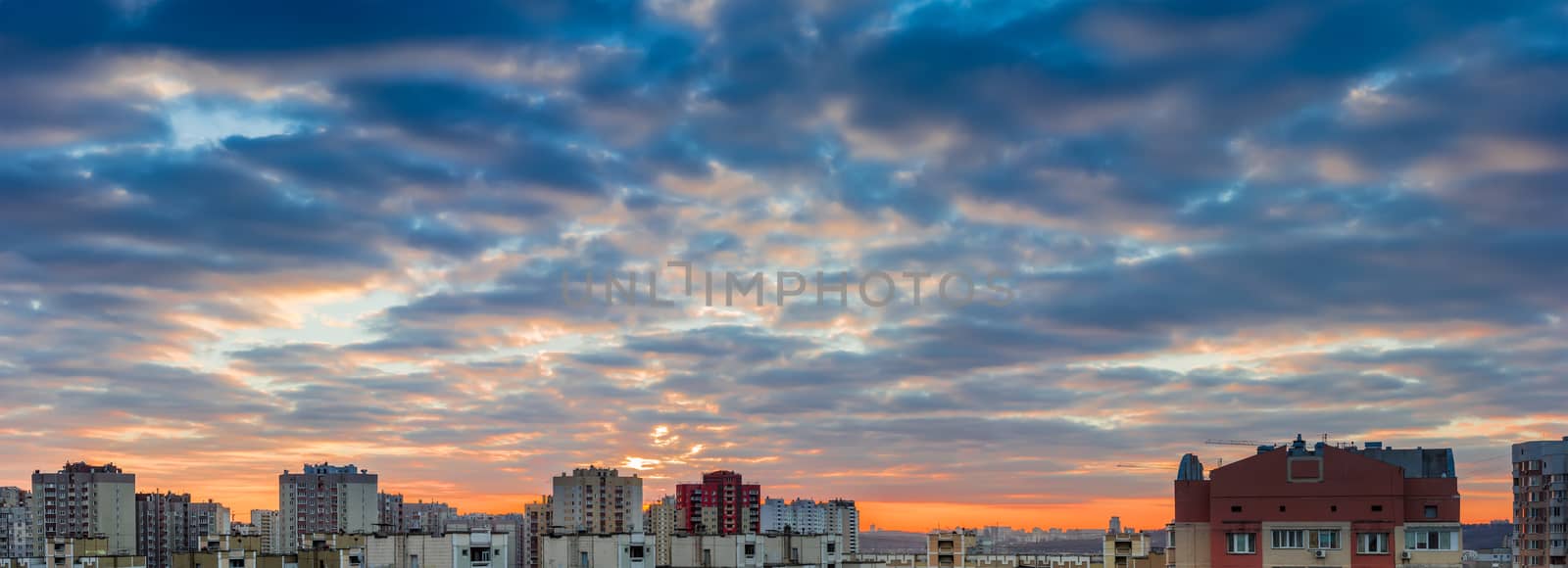 Panorama of a sunset over the housing estate with modern multi-storey apartment buildings in a big city
