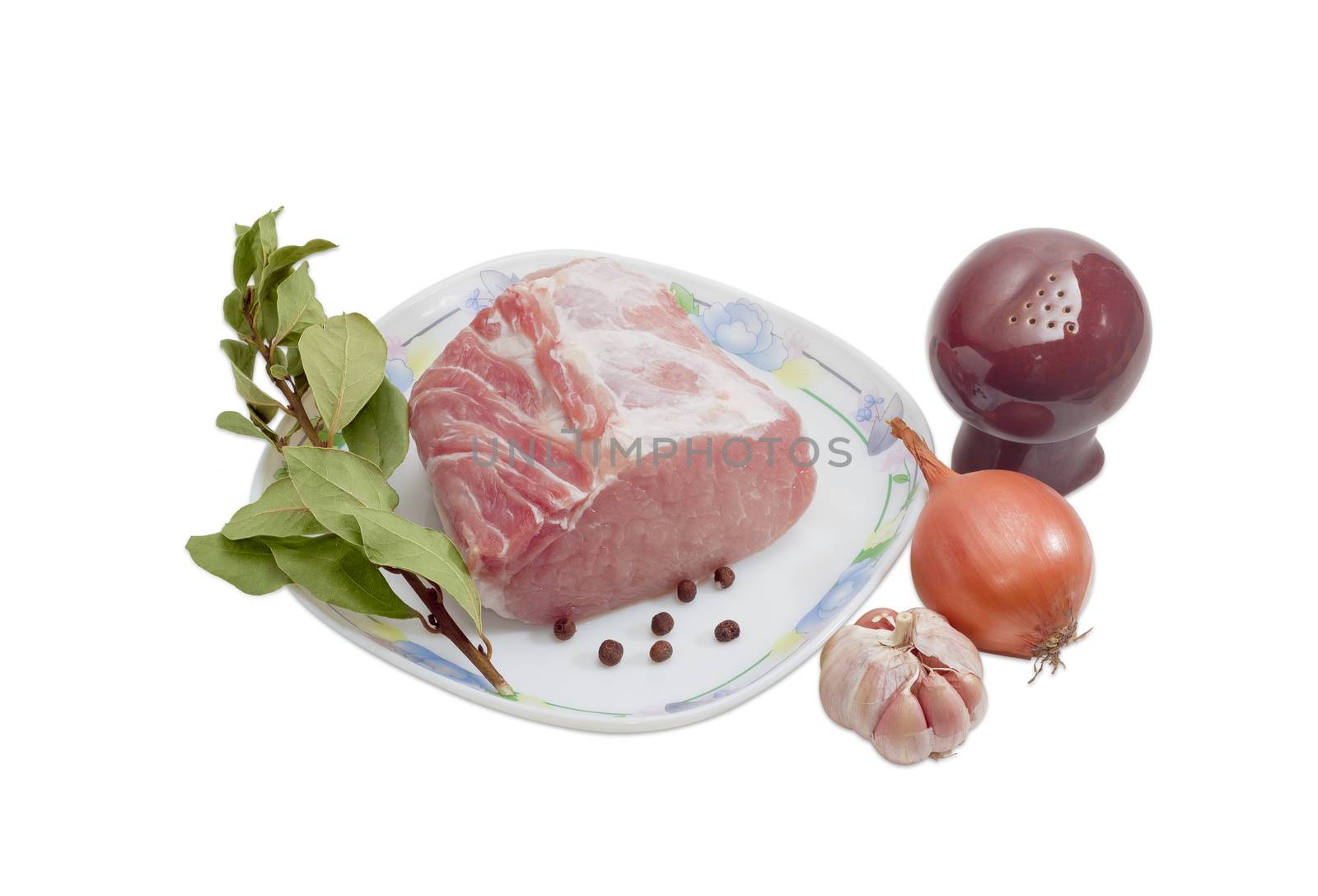 Piece of a fresh uncooked pork tenderloin, branch with dried bay leaves and a few peas allspiceon on dish, onion, garlic and pepper shaker on a light background 
