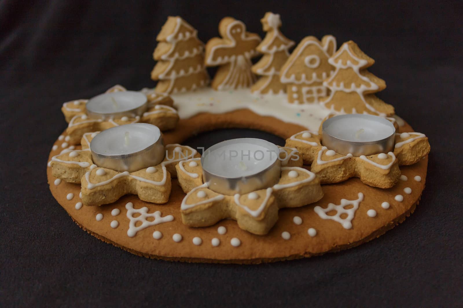 gingerbread wreath with candles on a dark background