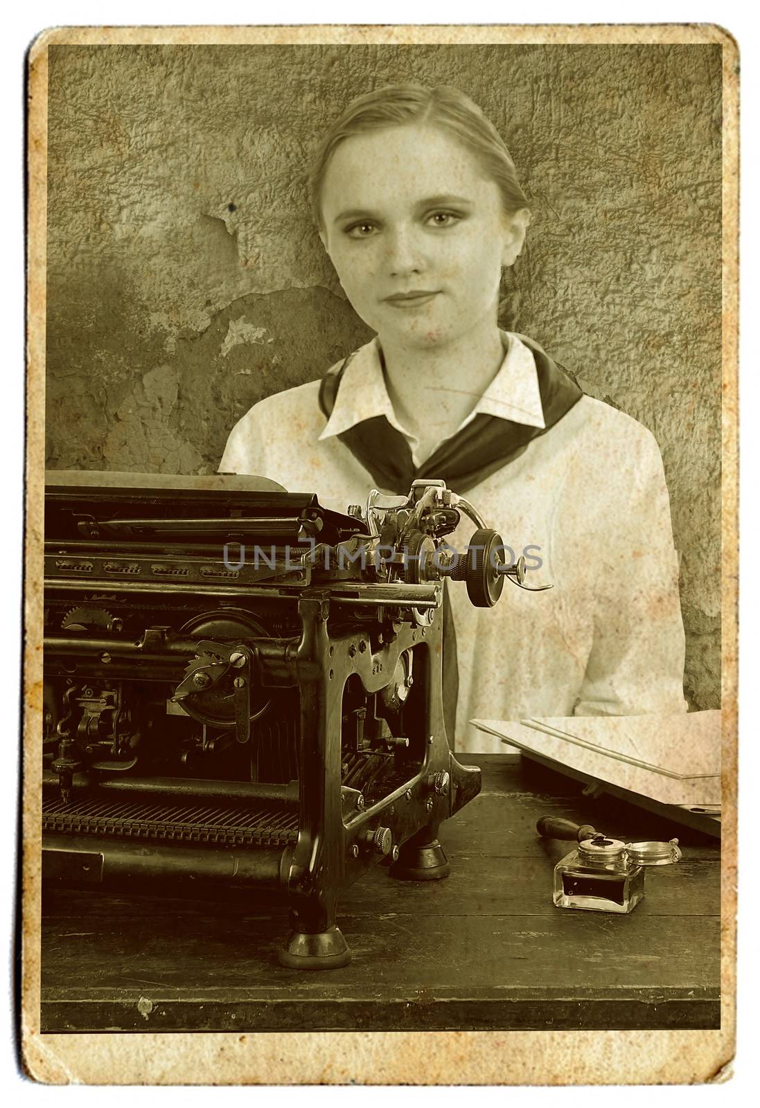 Young girl typist with an old typewriter on a white background