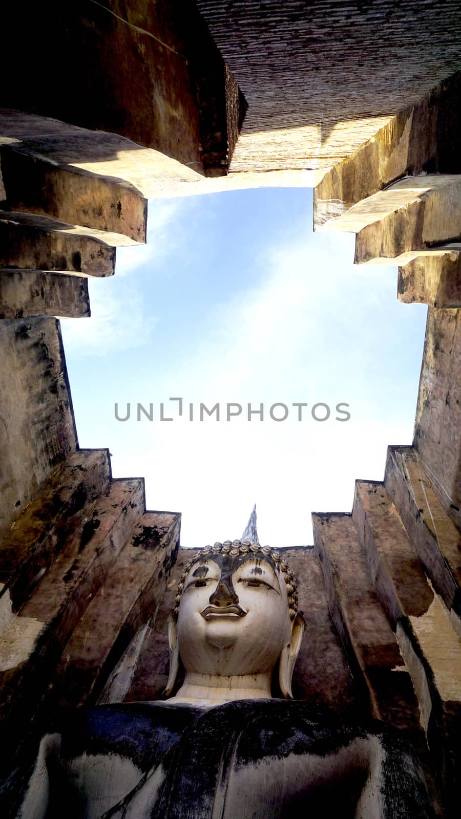 Historical Park Wat Sri chum temple bhudda statue up worm eye view in Sukhothai world heritage