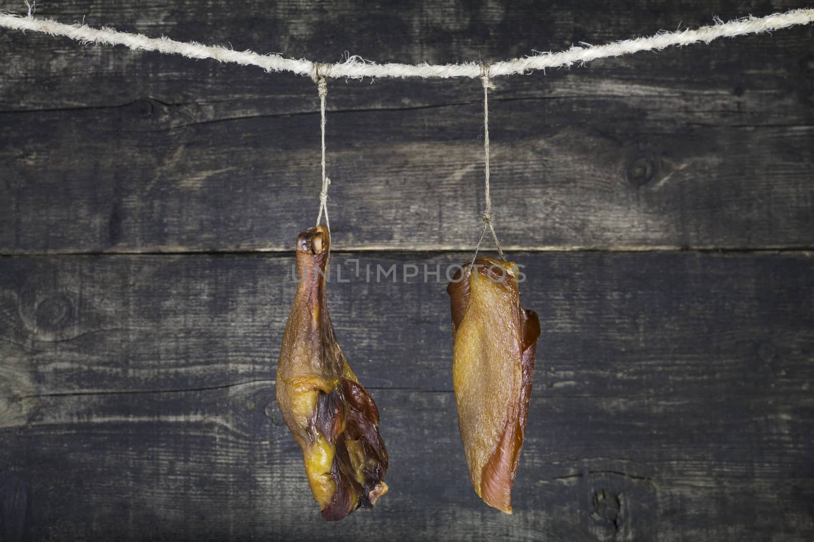Smoked Chicken Meat Hanging on the Rope Against Wooden Background