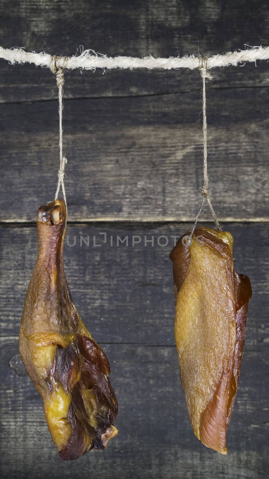 Smoked Chicken Meat Hanging on the Rope Against Wooden Background