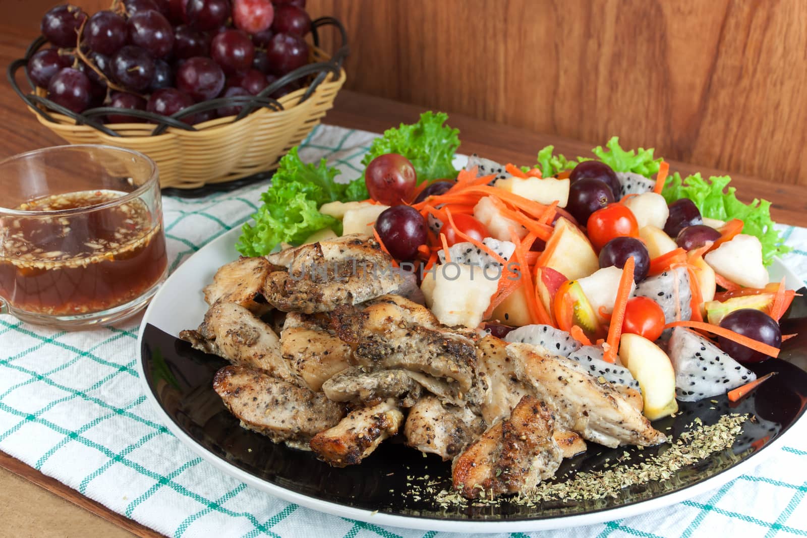 Healthy food. Grilled chicken sprinkled with oregano and mix fruit salad spicy on a plate.