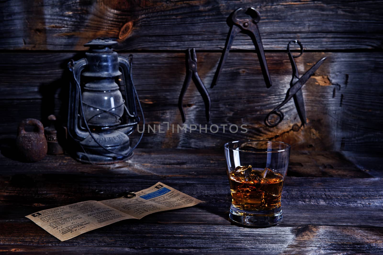 A glass of whiskey in an old wooden workshop