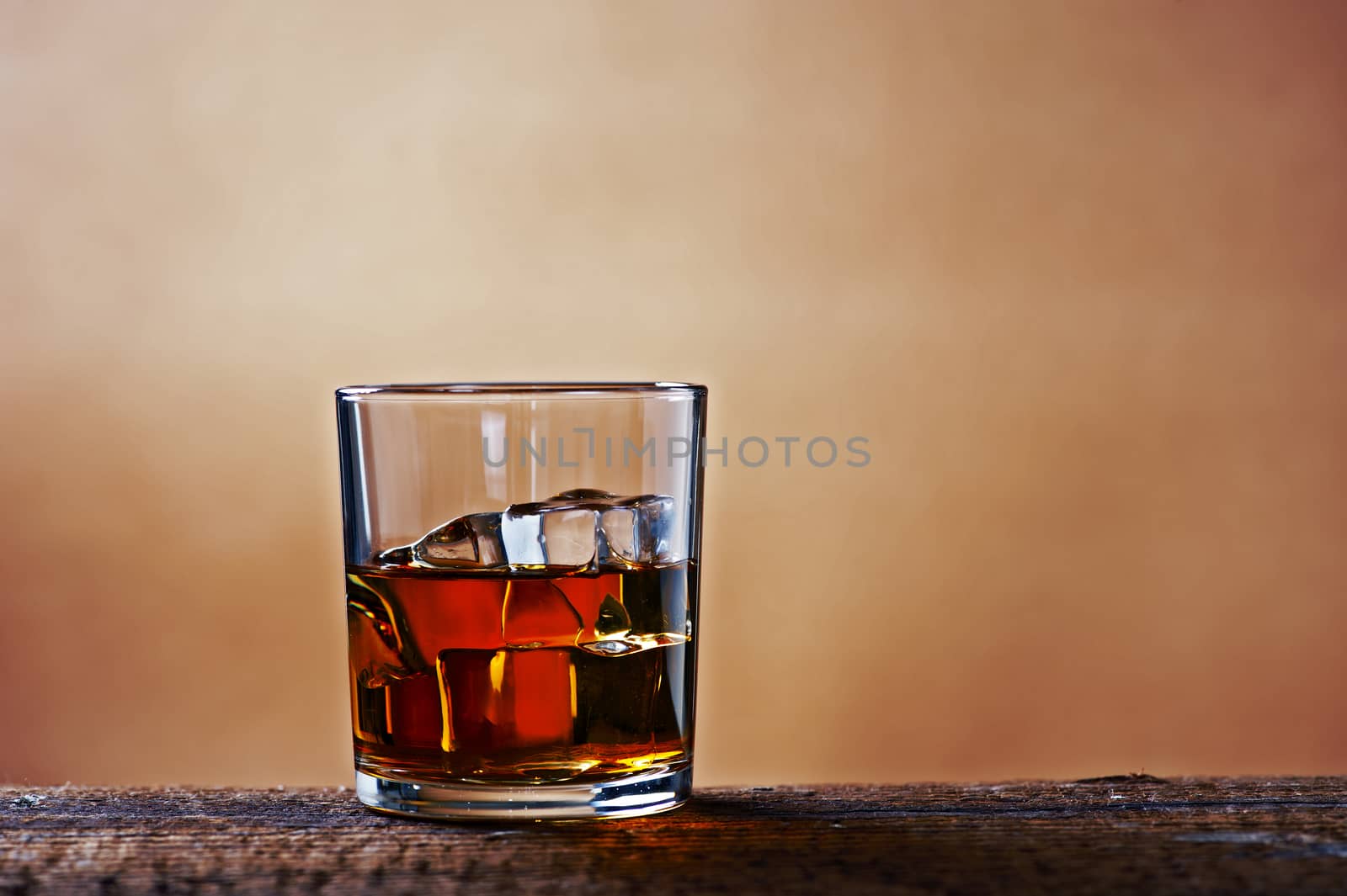 A glass of whiskey on a wooden table