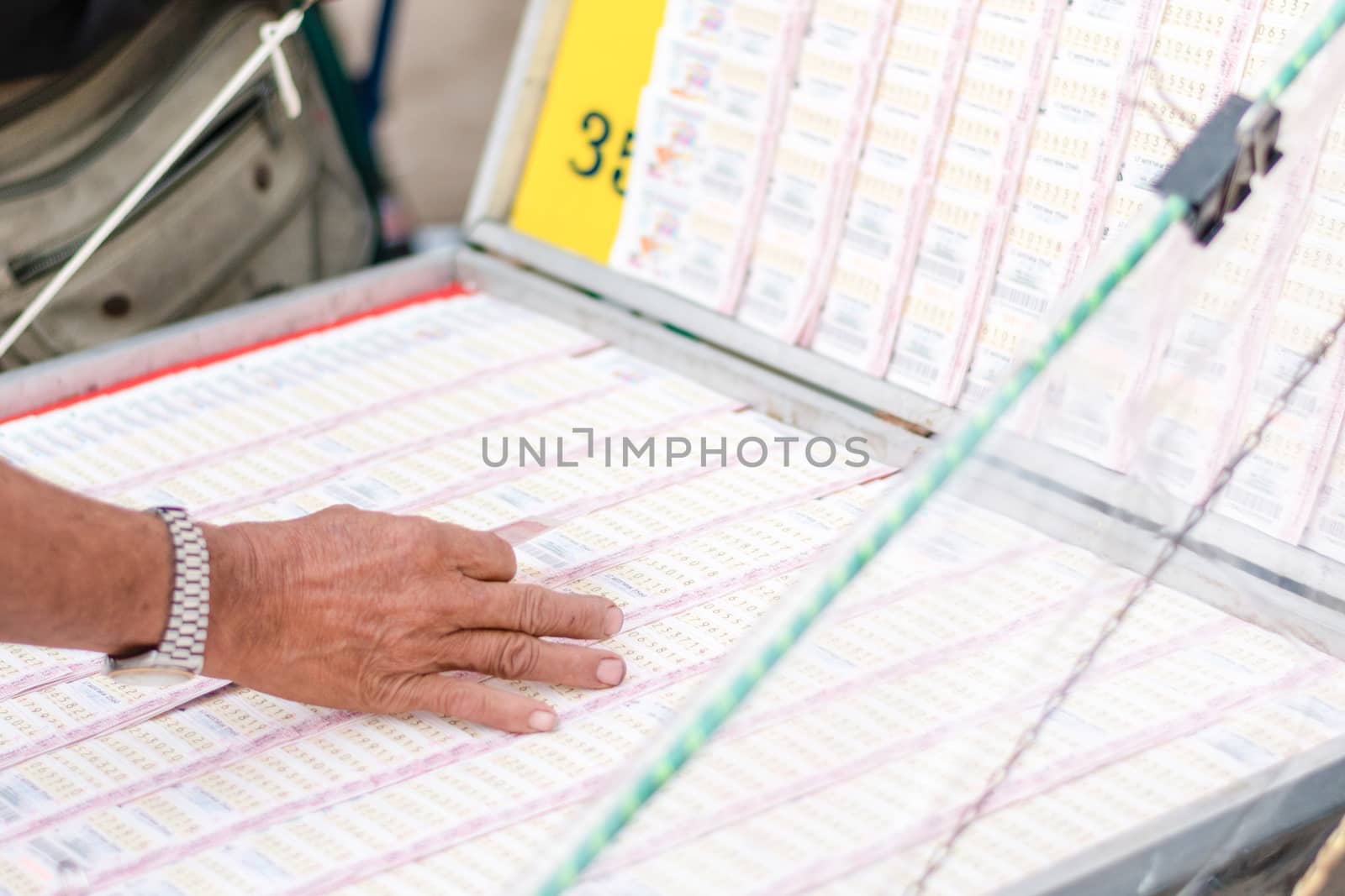 Man buying lottery at the counter. Thai lottery offers a form of by dfrsce