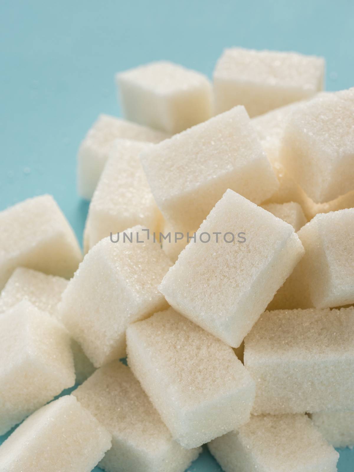 Background of sugar cubes. White cube sugar on blue background. White sugar close up