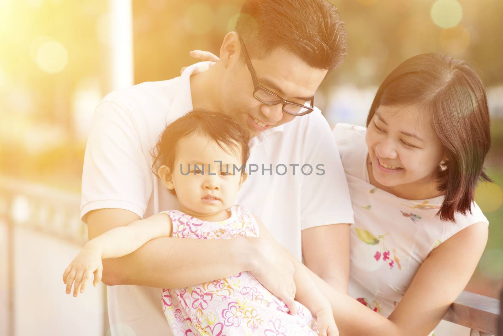 Portrait of young happy family enjoying holiday vacation together, outdoor walking on beautiful sunset.