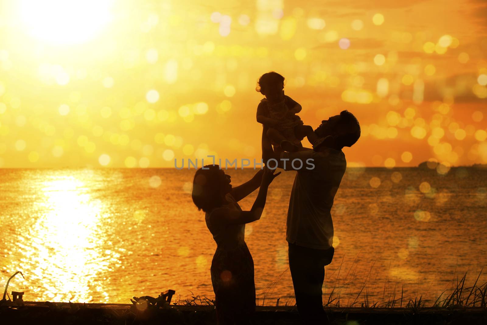 Silhouette of happy family outdoor activity, enjoying holiday together on coastline in beautiful sunset during vacations.
