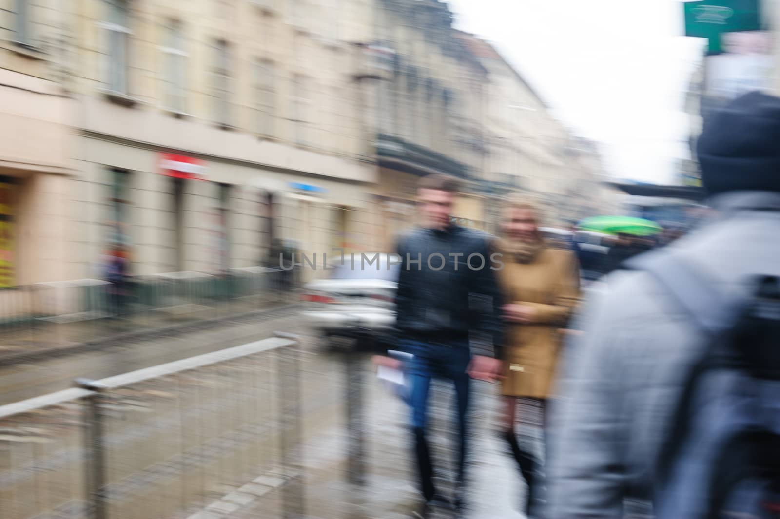 People walk down the street in rain. blurred focus by timonko