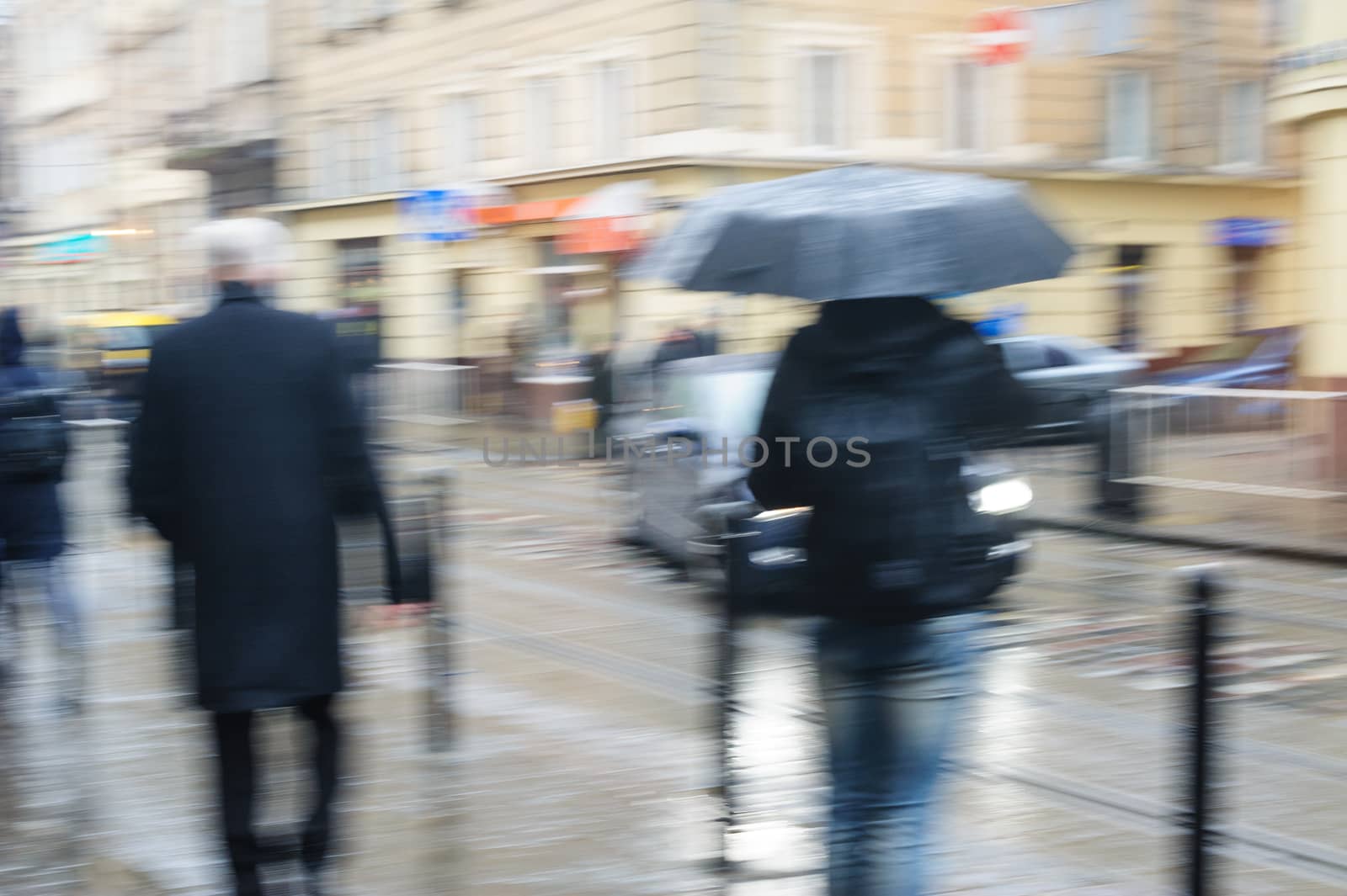 People walk down the street in rain. blurred focus.