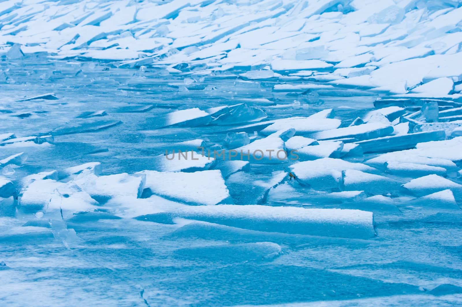 Winter scene at a frozen lake with ice-pack and other ice formations