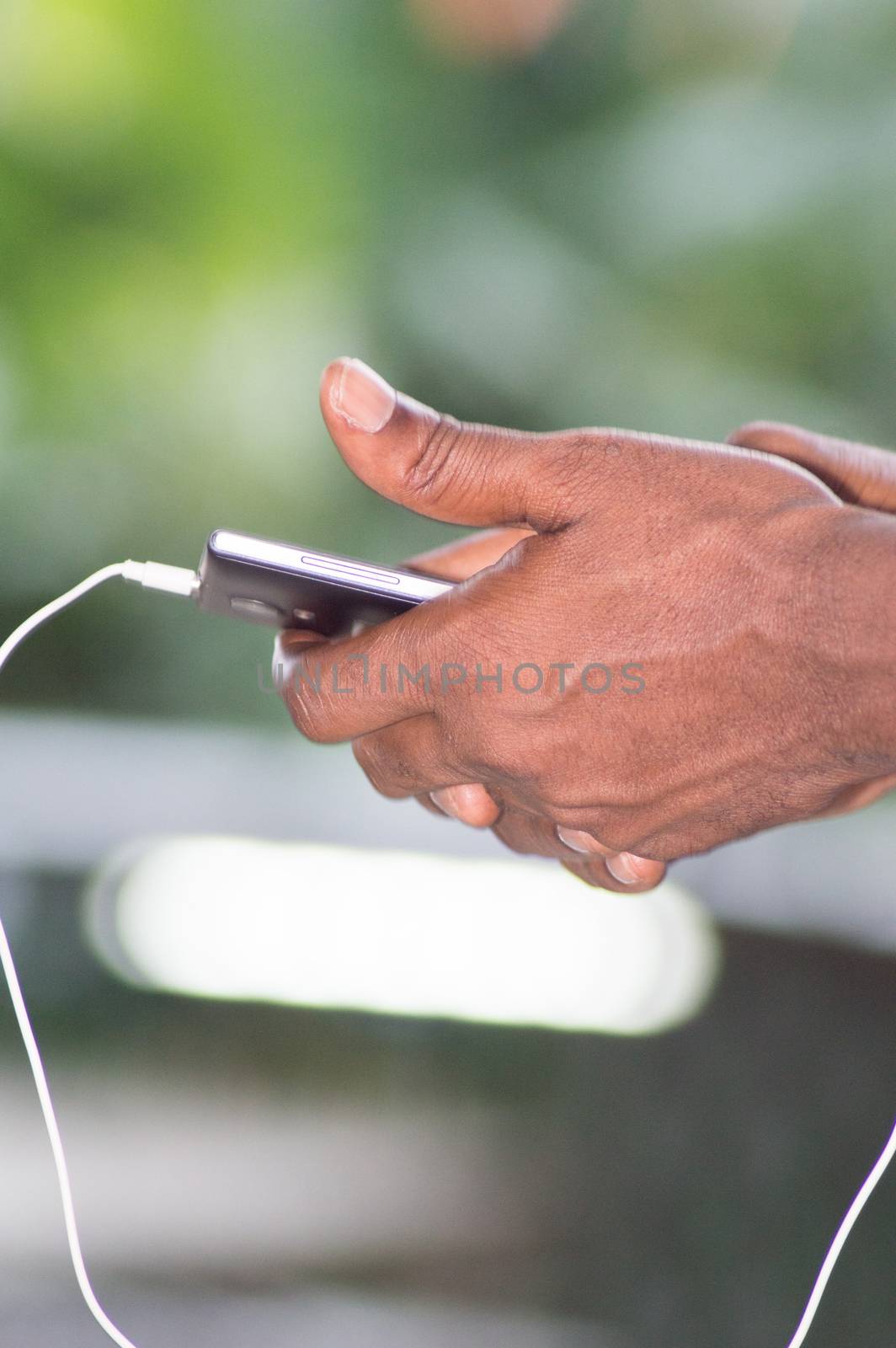 mobile phone manipulated with both hands of a person.