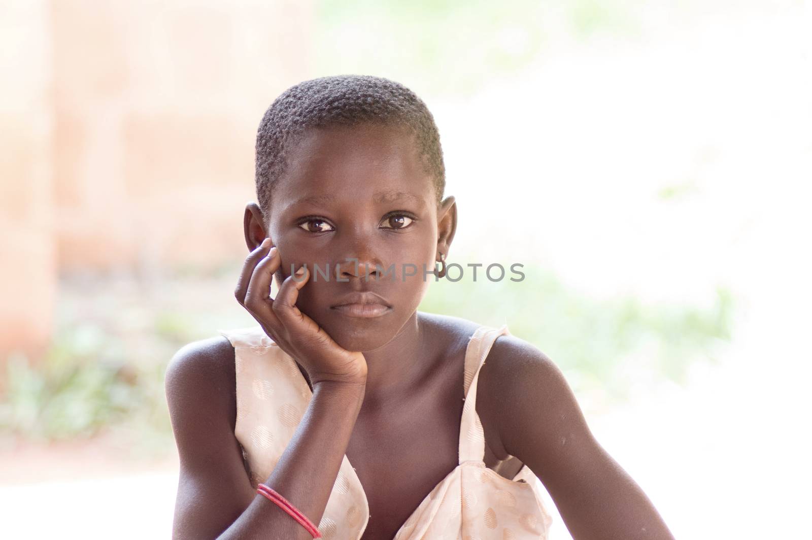 This girl sitting gaze to the camera and hand under chin , seems to be hungry.