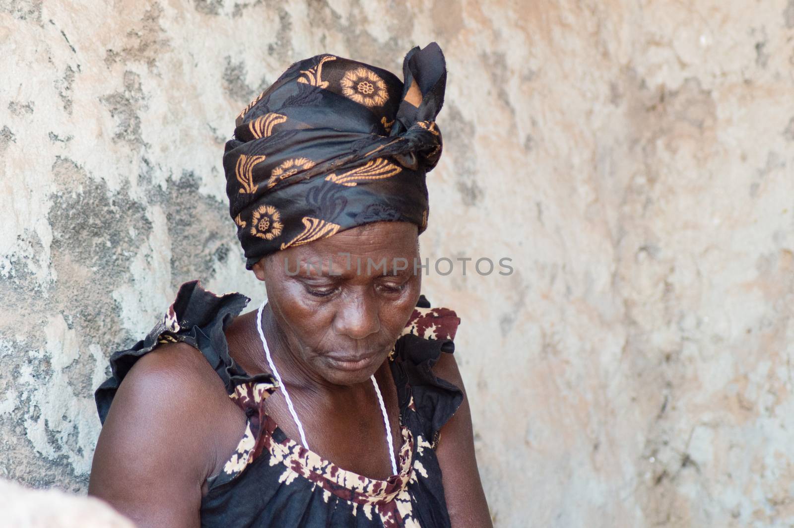 This woman is dressed like most African women living in the village. The head tied with a scarf and with a camisole loincloth
