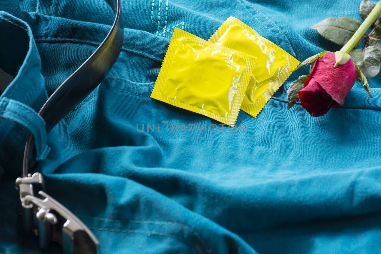 Pack condoms  with roses on pants with belt.Sex or story valentine day.Close up1 by engphoto