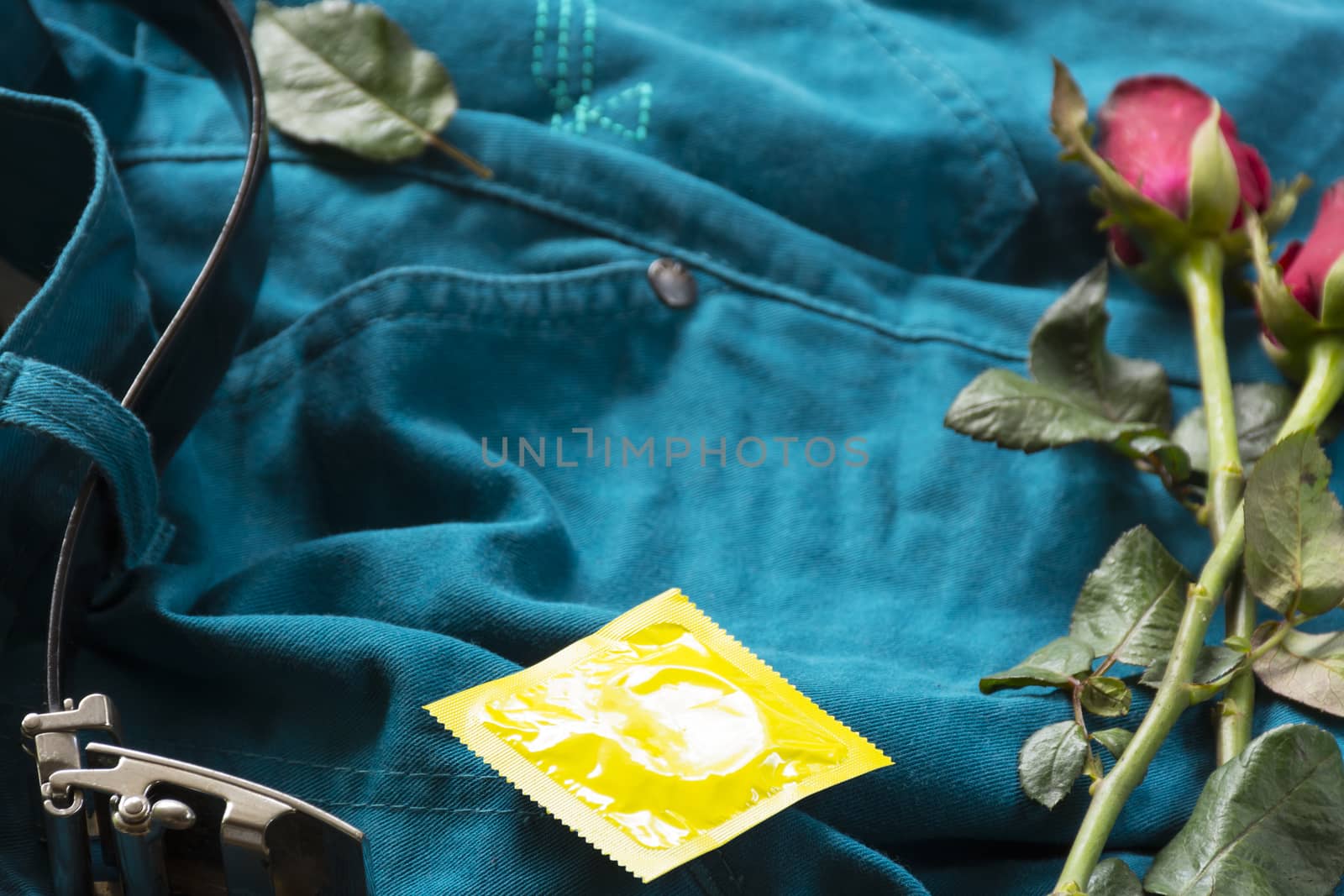 Pack condoms  with roses on pants with belt.Sex or story valentine day.Close up