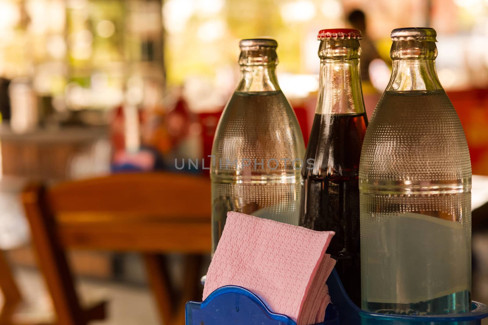 Water bottles and soft drink bottle and Tissues  papers on table and background restaurant in Asia. by engphoto