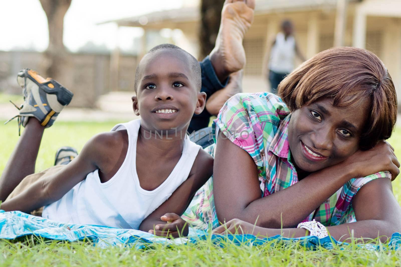 This woman and her child are happy to rest in the  grass.