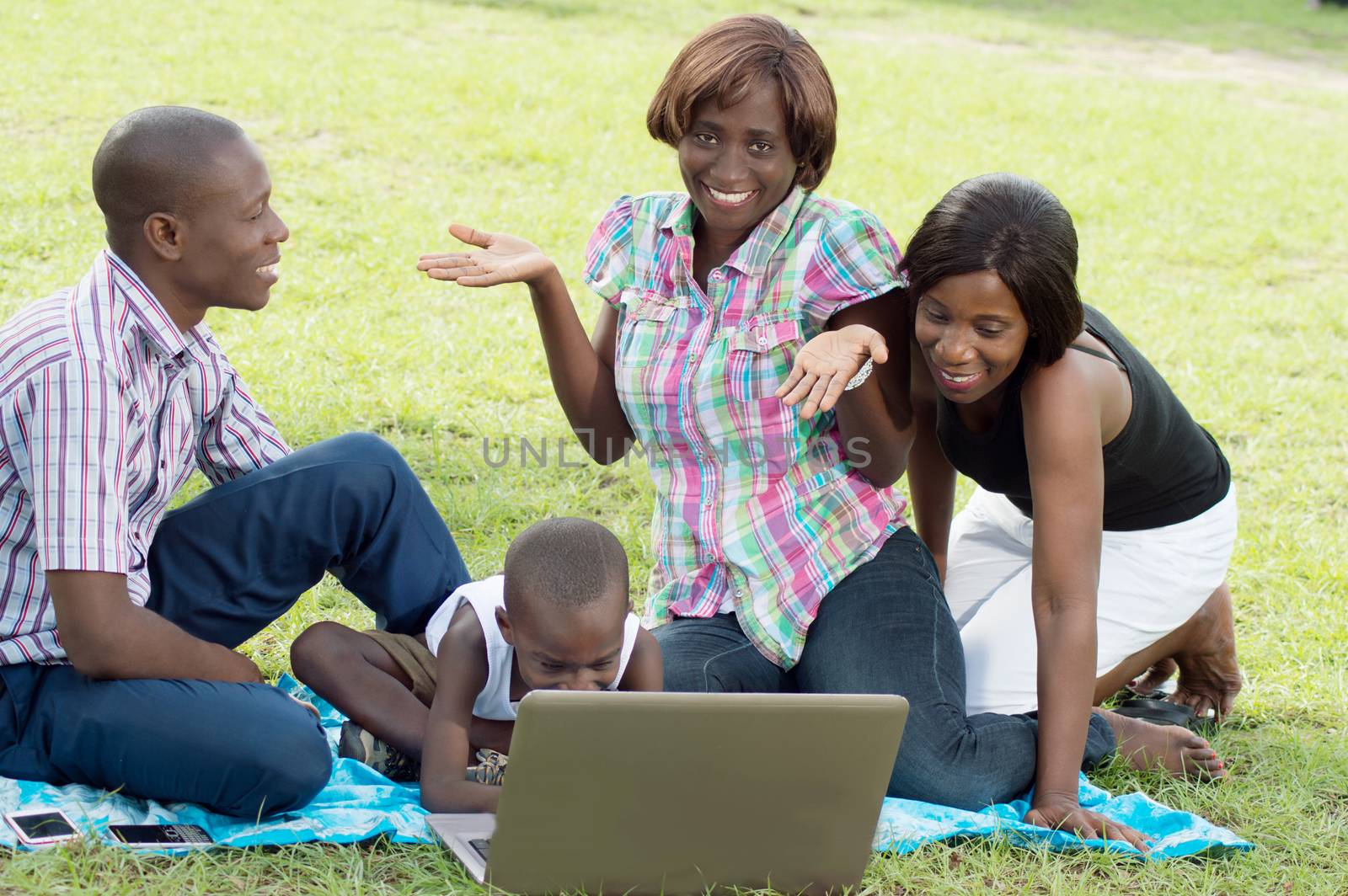 The child tap on the keyboard of the laptop , and one of the young women asks what he wants.