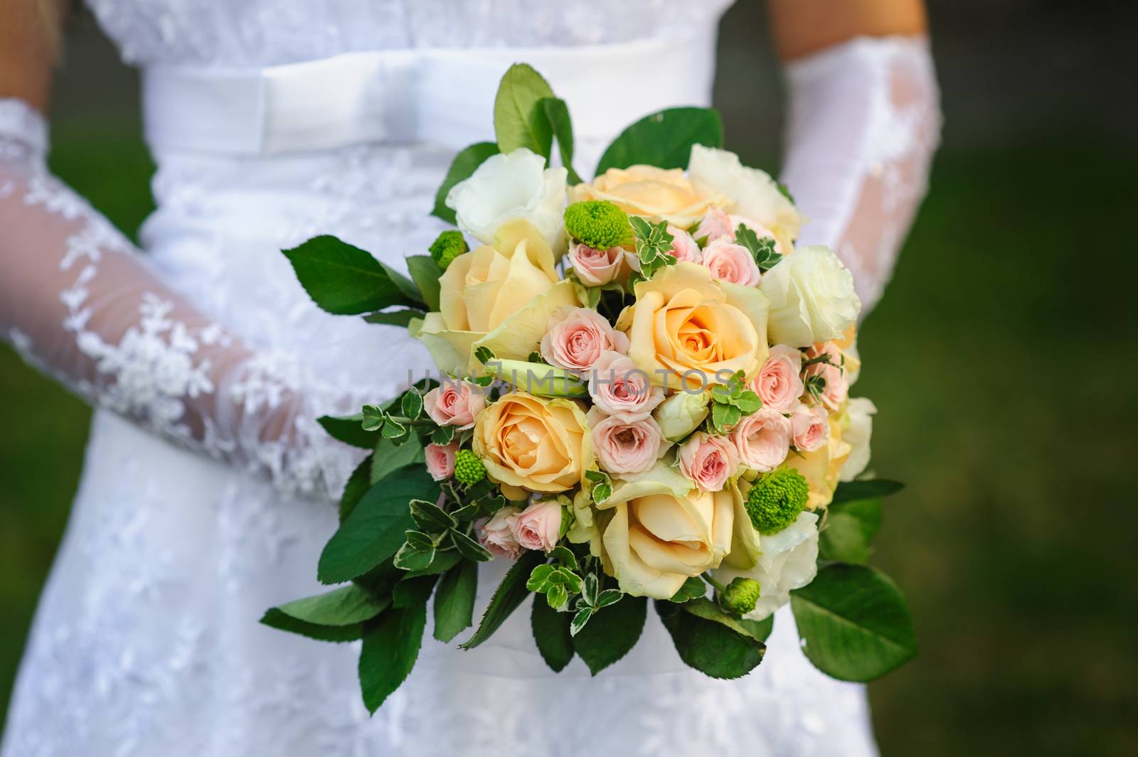 Bride holding beautiful wedding bouquet on a walk.