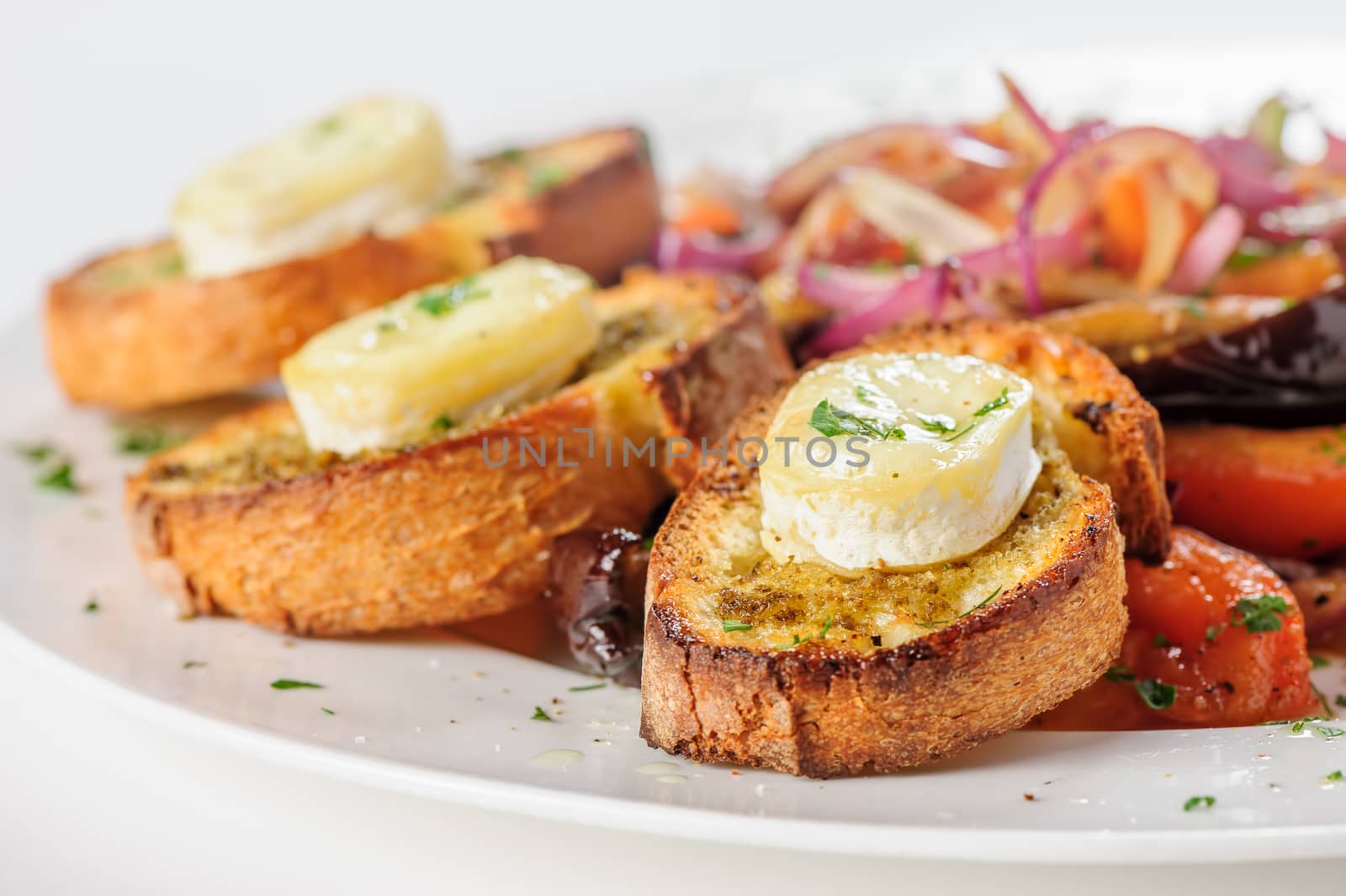 Grilled cheese on bread with salad of tomato, eggplants, red onion and lettuce, selective focus