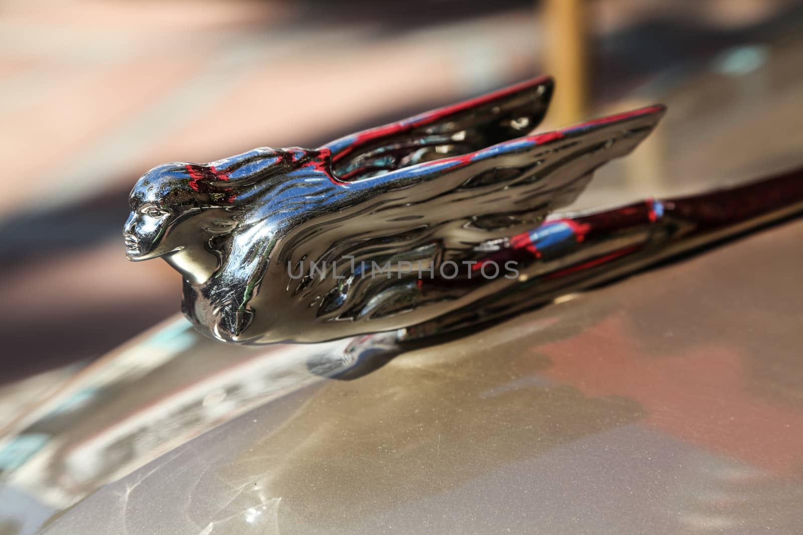 The hood ornament of a car shaped like a person with wings