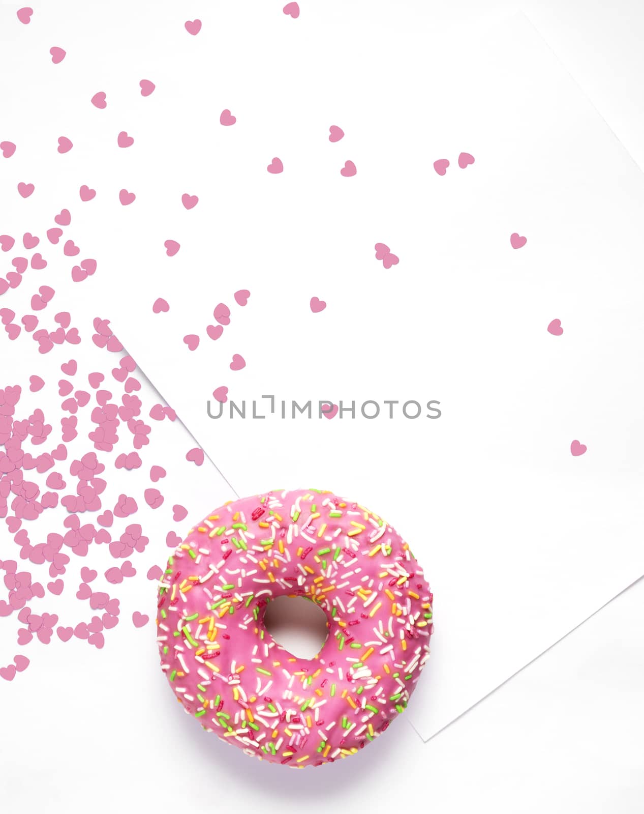 Creative concept photo of  a donut with hearts and card on white background.