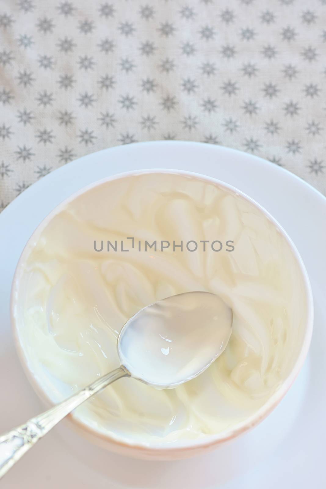 empty ceramic bowl of white yoghurt and spoon