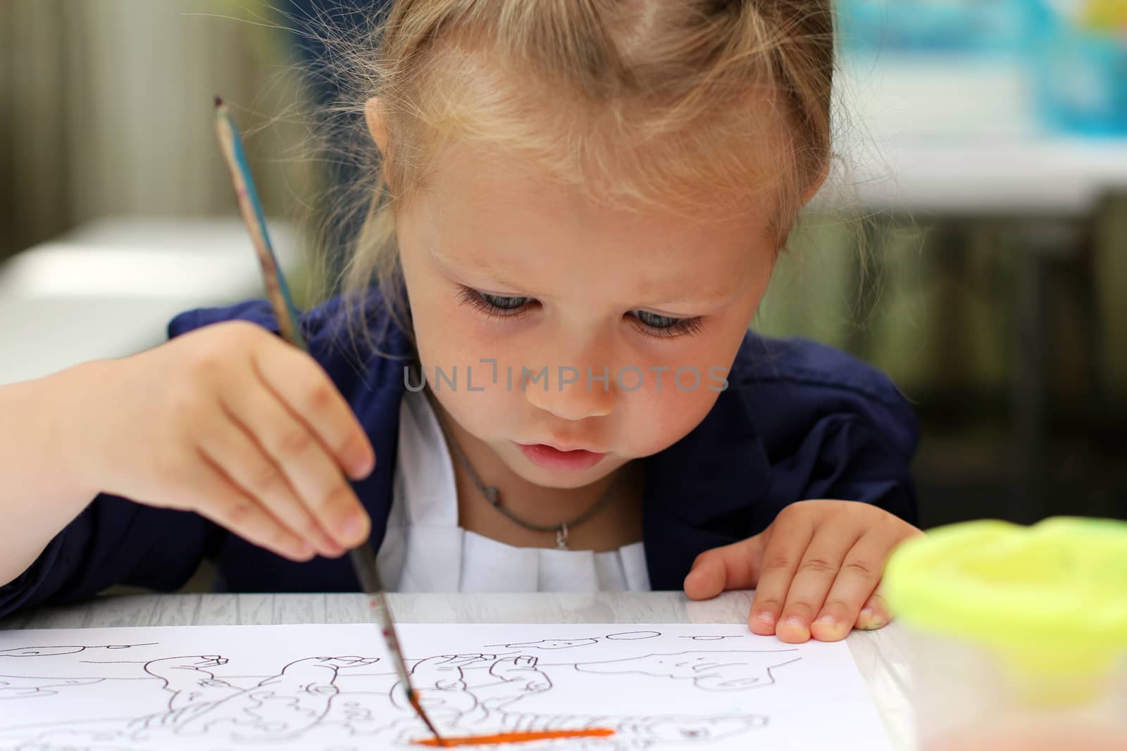 Cute little girl painting watercolors