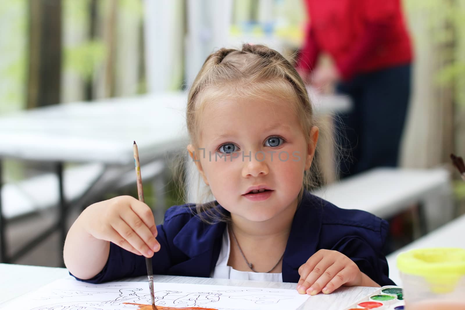 Cute little girl painting watercolors by friday