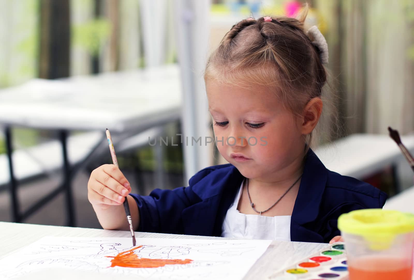 Cute little girl painting watercolors by friday