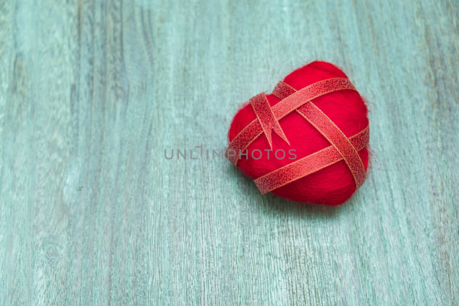 Ribbon wrapped heart on wood background