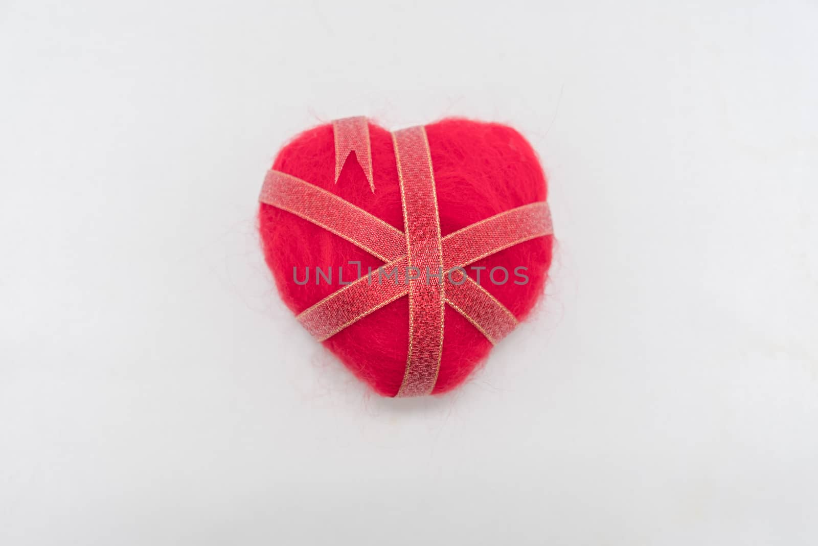 Ribbon wrapped heart on wood background