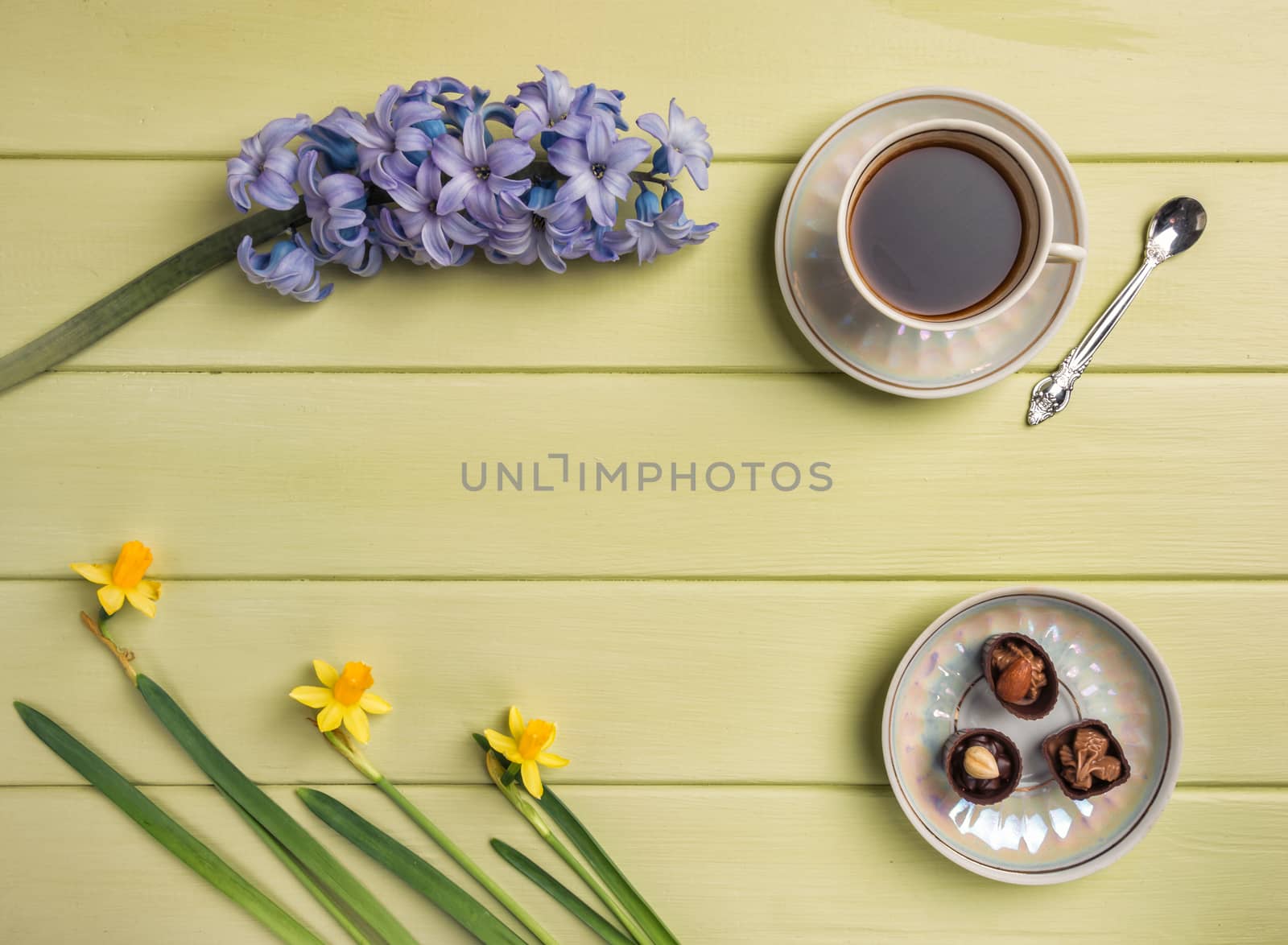 Cup of black coffee,  and flowers on a wooden background. Top view. Copy space