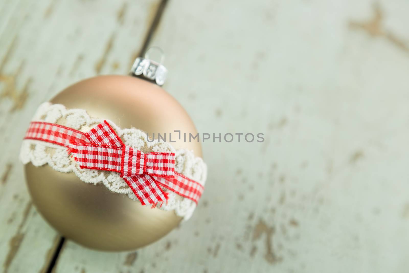 Three colorful decorated Christmas baubles on rustic wood with copy space to celebrate the Xmas holiday season