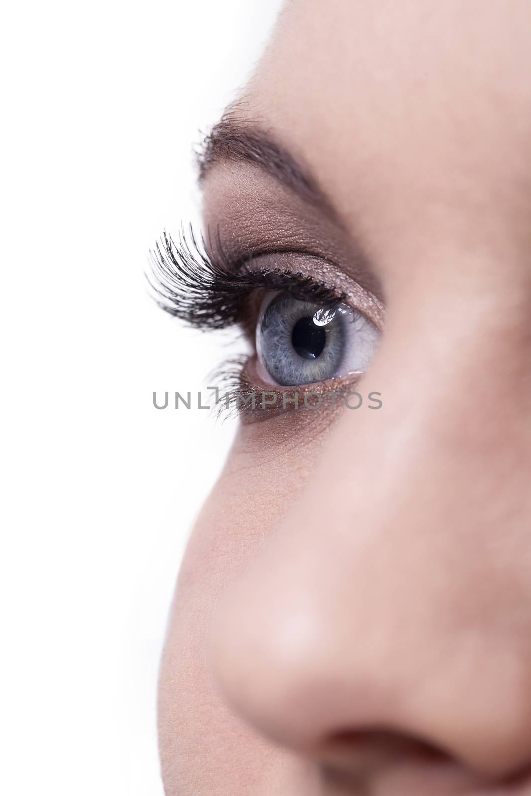 Close up of single human female blue eye with long dark lashes and one nose on white background