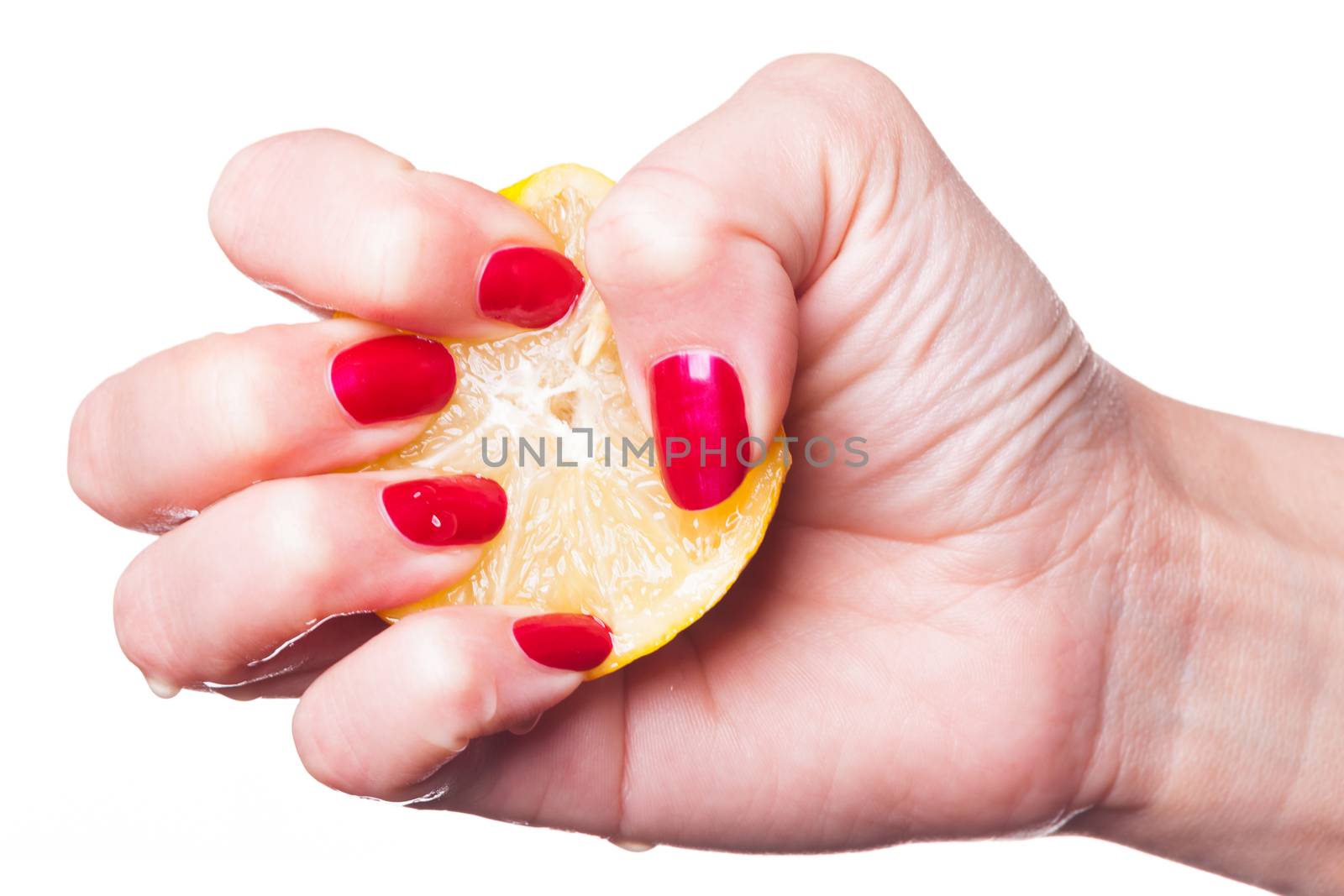 Hand with manicured nails painted a deep glossy red squeeze lemon on white background