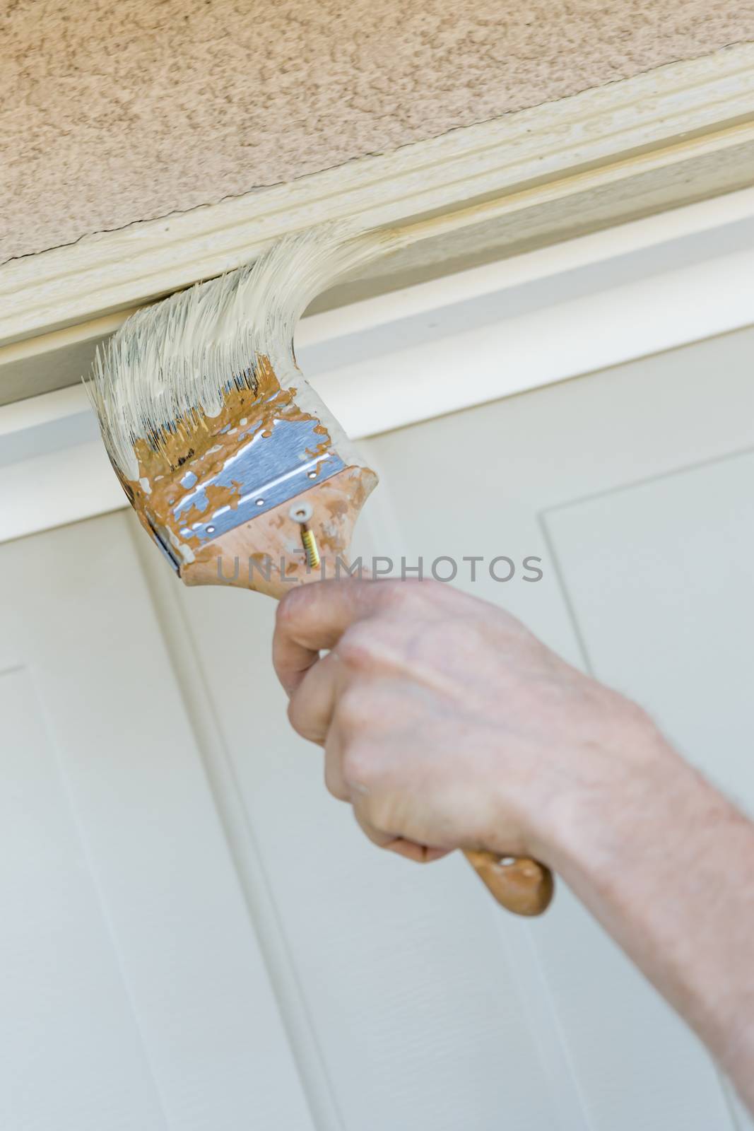 Professional Painter Cutting In With A Brush to Paint Garage Door Frame.