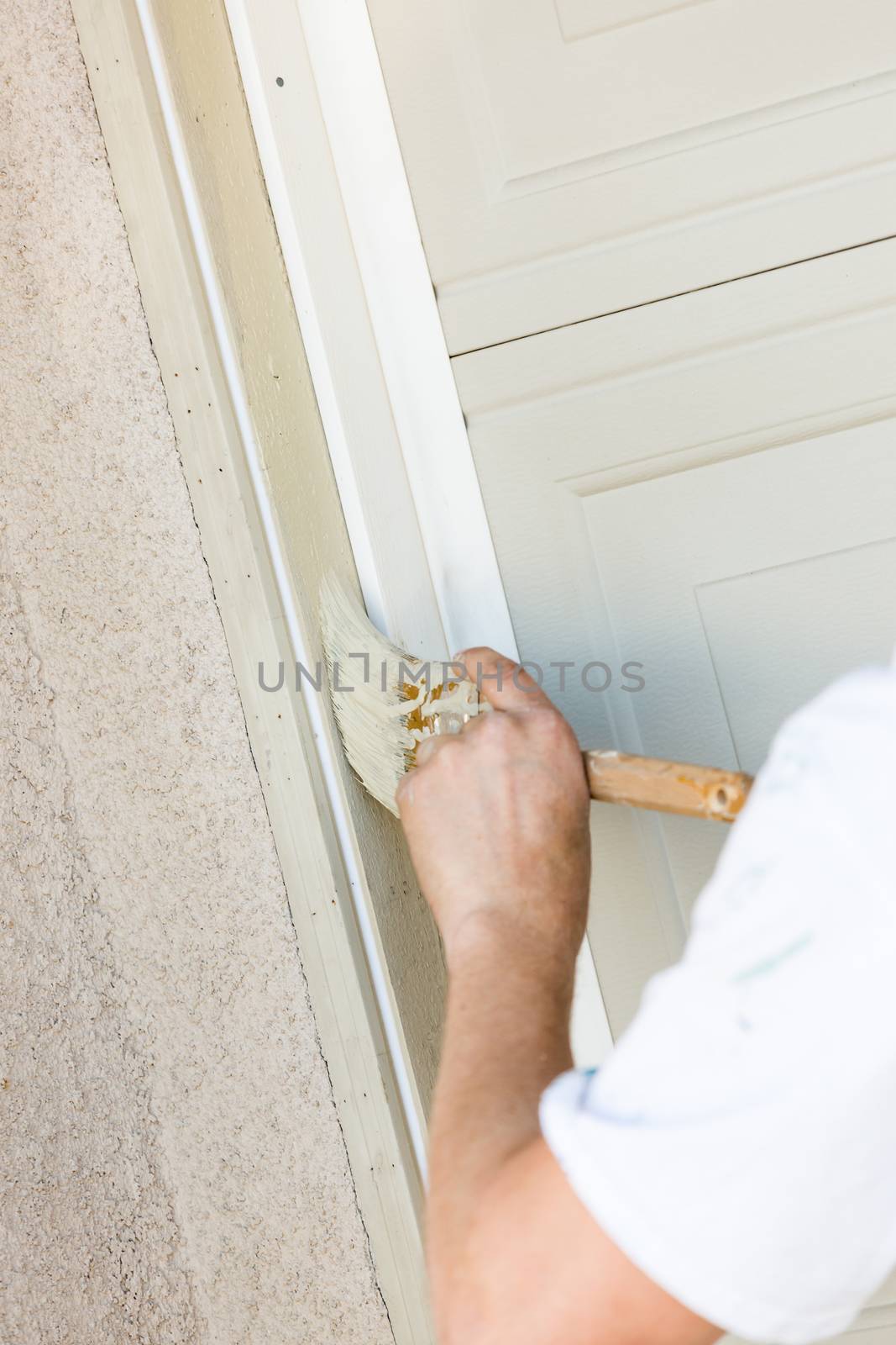 Professional Painter Cutting In With A Brush to Paint Garage Door Frame.