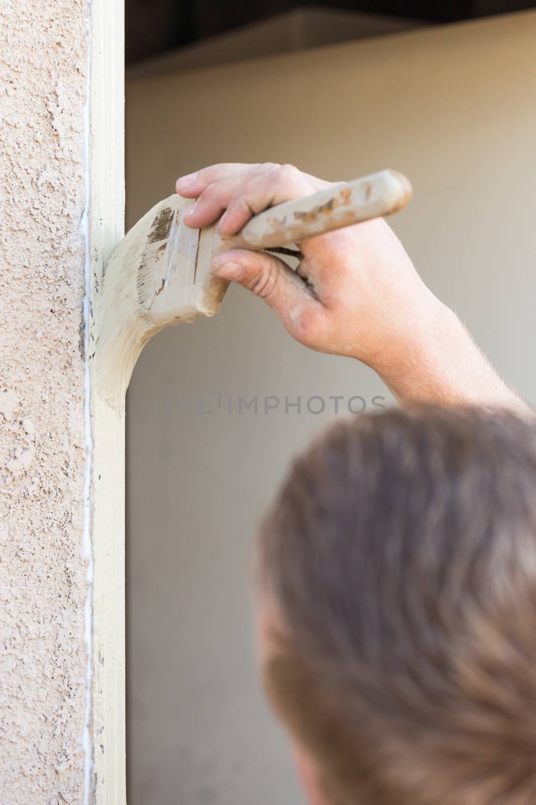 Professional Painter Cutting In With A Brush to Paint House Door Frame.