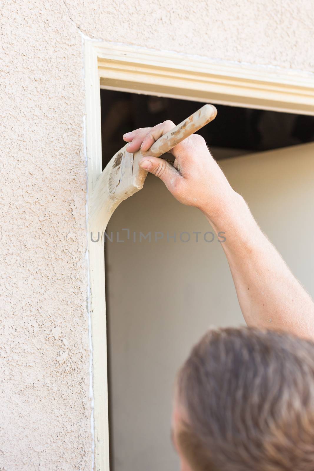 Professional Painter Cutting In With A Brush to Paint House Door Frame.