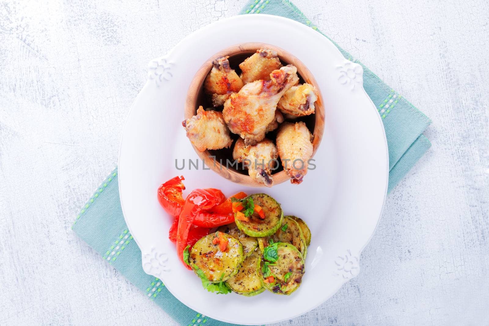 Fried chicken wings and zucchini, pepper on a white background