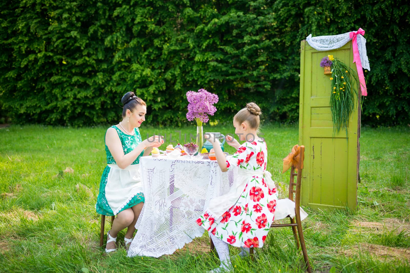 mother with daughter have a breakfast in the garden